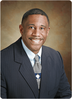 Headshot of Dr. Calvin T. Wilson II, MD, Clinical Advisor to Crystal Clear RX Wellness, in a suit and tie against a neutral backdrop.